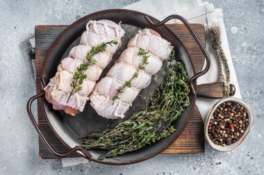Raw chicken rolls stuffed with cheese and ham. Gray background. Top view.