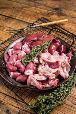 Raw bird giblets meat set, chicken offals, liver, hearts, gizzards Stomach. Wooden background. Top view.
