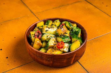 Pai huang gua Chinese Smashed Cucumber salad. Orange background. Top view.