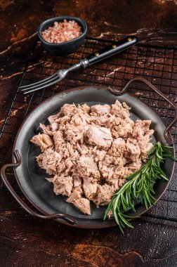 Canned tuna with fresh herbs ready for eat. Dark background. Top view.