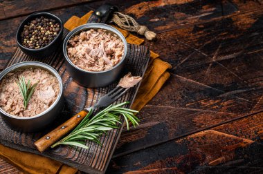 Can with Conserved tuna fillet meat. Wooden background. Top view. Copy space.