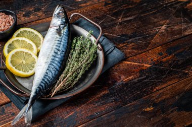 Uncooked mackerel fish, raw scomber with herbs. Wooden background. Top view. Copy space.