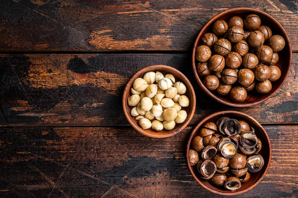 Unshelled Macadamia nuts ready to eat. Wooden background. Top view. Copy space.