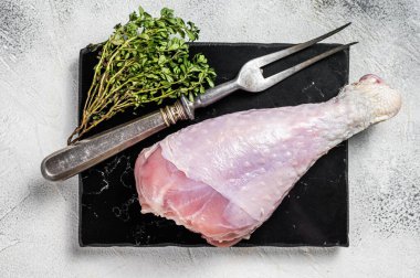 Raw turkey leg thigh with thyme and spices. White background. Top view.
