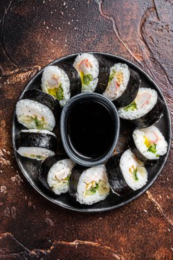 Korean rice roll Kimbap or gimbap made from steamed white rice. Dark background. Top view.