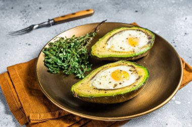Brunch with Baked Avocado and Egg. Gray background. Top view.