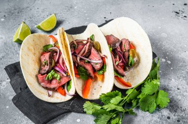 Homemade Mexican Steak Steet Tacos with Cilantro, green sauce, jalapenos and onion. Gray background. top view.