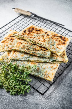 Gozleme Turkish stuffed pastrie, flatbread with greens and cheese. White background. Top view.