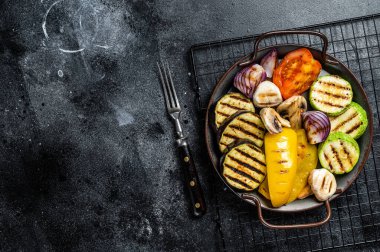 Grilled vegetables, bell pepper, zucchini, eggplant, onion and tomato. Black background. Top view. Copy space.