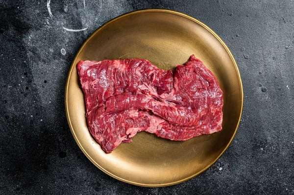 Alternative choice steak - Skirt or Machete, raw beef meat. Black background. Top view.