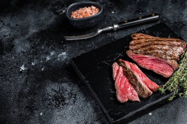 Grilled Wild Venison steak with thyme and salt, game meat. Black background. Top view. Copy space.