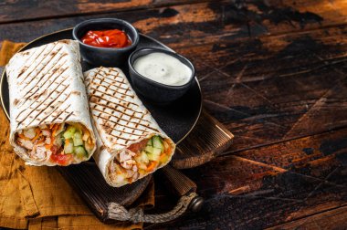 Shawarma, Shaurma chicken roll with vegetable salad. Wooden background. Top view. Copy space.