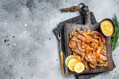 Gravlax Cured Salmon fillet with dill, salt and papper, lox. Gray background. Top view. Copy space.
