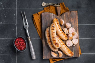 German grilled Bratwurst pork meat sausages on a wooden board. Wooden background. Top view.