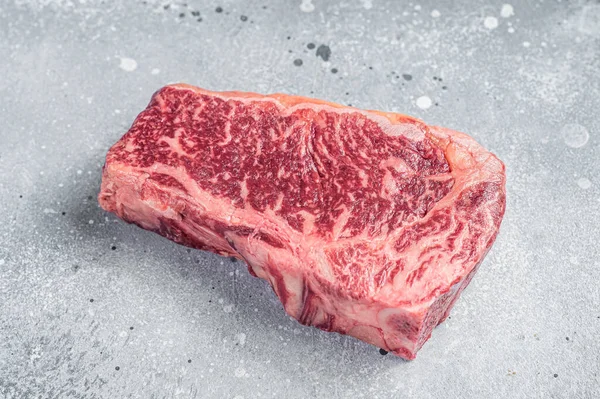 在屠夫桌上放着生瓦格纳肉片或纽约的牛排 灰色背景 顶部视图 — 图库照片