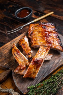 Grilled pork Baby Back spare ribs on a wooden board. Wooden background. Top view.