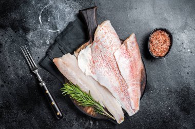 Fresh Raw red perch fillet, Snapper fish on a wooden board. Wooden background. Top view.