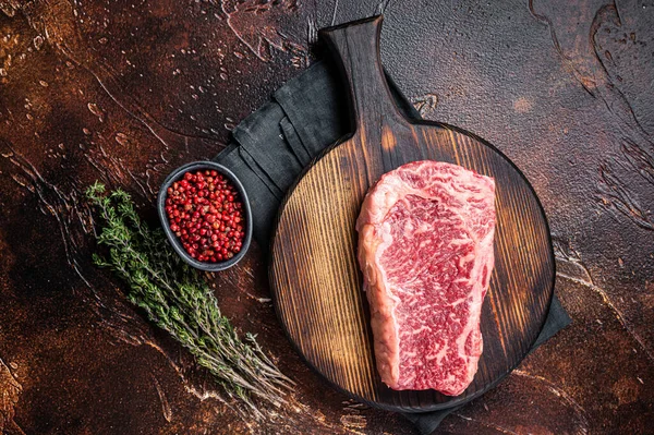 Uncooked Raw Striploin Club Steak Wooden Board Thyme Dark Background — стоковое фото