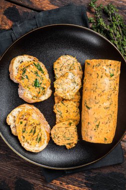 Butter with flavoring additives, sandwich butter with fresh herbs, sweet peppers, lemon, onion, garlic. Wooden background. Top view.