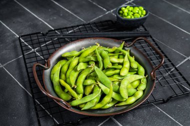 Green Edamame Beans, raw soy beans ready for cooking. Black background. Top view.