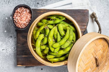 Steamed Edamame Beans with sea salt, soy beans. Gray background. Top view.