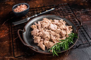 Canned tuna with fresh herbs ready for eat. Dark background. Top view.