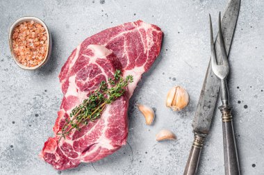 Raw Pork steaks, fresh meat on butcher table. Gray background. Top view.