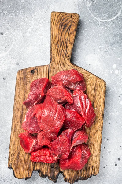 Raw organic diced lamb meat for cooking Goulash. Gray background. Top view.