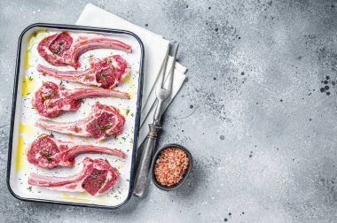 Baharatlı ve otlu kuzu pirzola pişirmeye hazırım. Gri arka plan. Üst Manzara. Boşluğu kopyala.