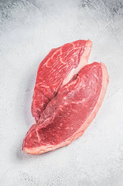 Raw top sirloin steak, cap rump beef meat steak. White background. Top view.