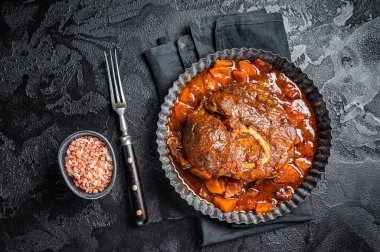 Kemiklerde haşlanmış et, domates soslu Osso Buco, İtalyan dana eti Ossobuco. Siyah arka plan. Üst görünüm.