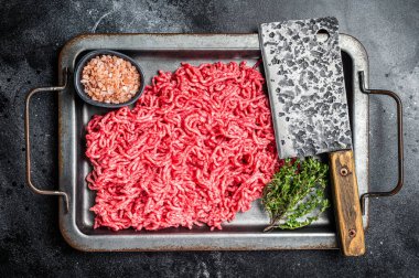 Çiğ et, kıyma ve mutfak tepsisinde domuz eti. Siyah arka plan. Üst görünüm.