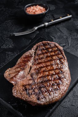 Misket tahtasında ızgara sığır filetosu ya da biftek. Siyah arka plan. Üst görünüm.