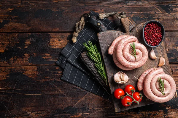 Bavarian Raw spiral sausages on a wooden board. Wooden background. Top view. Copy space.