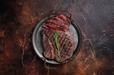 Izgara orta pişmiş sığır etli biftek ya da çelik tepside biftek. Karanlık arka plan. Üst görünüm.