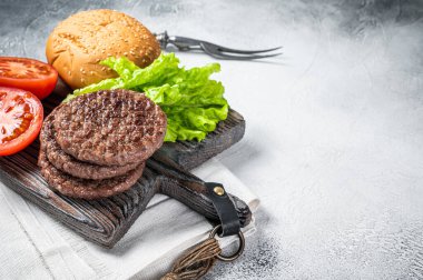 Sebzeli ve ahşap tahtada baharatlı hamburger için kızarmış pirzola. Beyaz arka plan. Üst Manzara. Boşluğu kopyala.