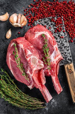 Et satırında çiğ Tomahawk pirzola bifteği. Siyah arka plan. Üst görünüm.