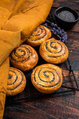 Sweet roll poppy seed buns with lavender ready for cooking. Wooden background. Top view.