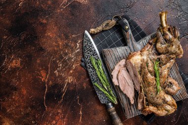 Slow Cooked grilled lamb mutton shoulder meat with herbs and spices on wooden board. Dark background. Top view. Copy space.