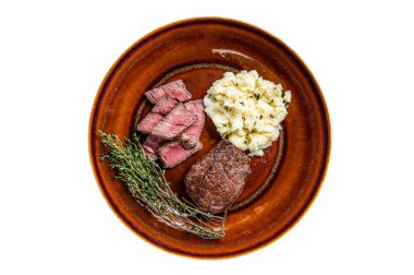 Köy tabağında dilimlenmiş fileminyon ya da bonfile biftek ve patates püresi. Beyaz arkaplanda izole
