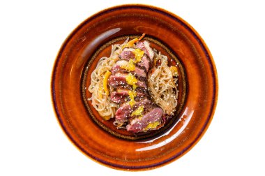 Tabakta ördek göğsü fileto bifteği olan erişte. Beyaz arkaplanda izole