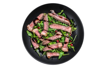 Dilimlenmiş biftek ve roka yapraklı salata. Beyaz arkaplanda izole