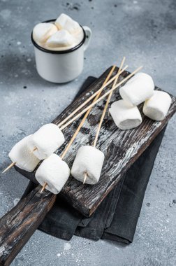 Marshmallow on the stick ready for BBQ. Gray background. Top view.