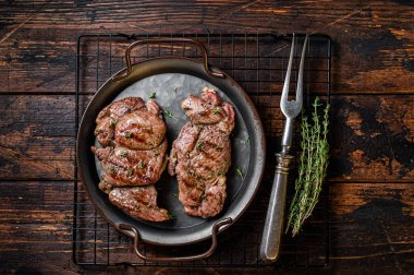 Grilled Lamb chop leg steaks, mutton meat with herbs. Wooden background. Top view.