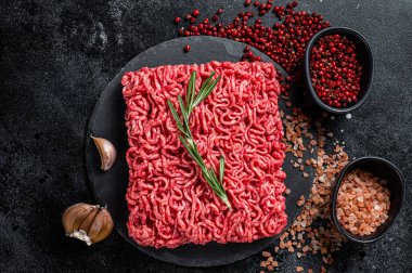 Uncooked beef veal Mince Meat, raw ground meat. Black background. Top view.