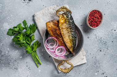 Roasted mackerel soba fish fillet with herbs in a skillet. Gray background. Top view.