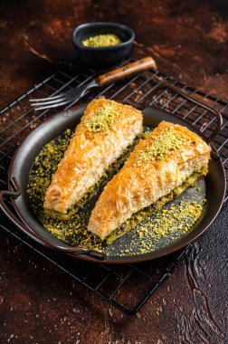 Turkish Havuc Dilim Baklava with pistachio. Dark background. Top view.