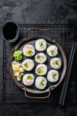 Kimbap gimbap filled with vegetables, egg, eanchovy and crab, Korean rice roll. Black background. Top view.