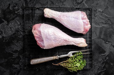 Raw turkey legs on a butcher table. Black background. Top view.