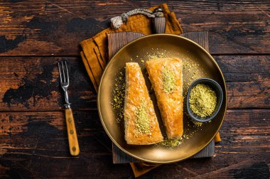 Carrot Slice Baklava, Turkish Havuc Dilim Baklava with pistachio. Wooden background. Top view.